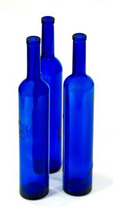 Three blue glass tequila bottles against white background
